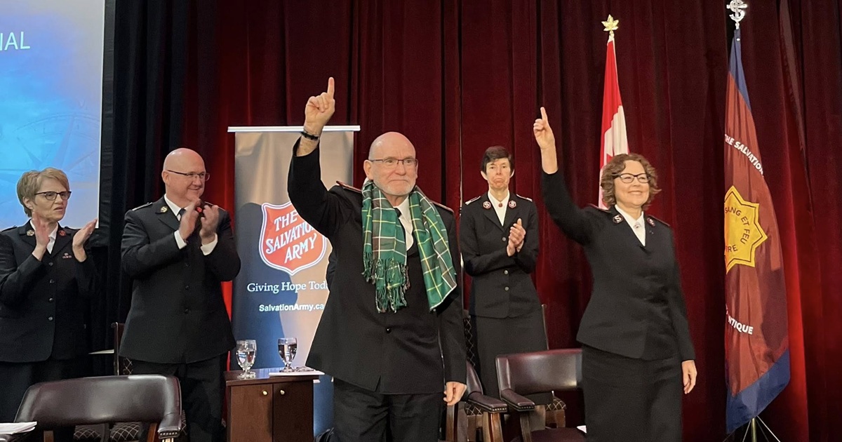 Five people: three clapping, two raising their right arms in a salute